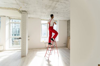 Elektrikçi odada tavan ışığına halojen lamba monte eder