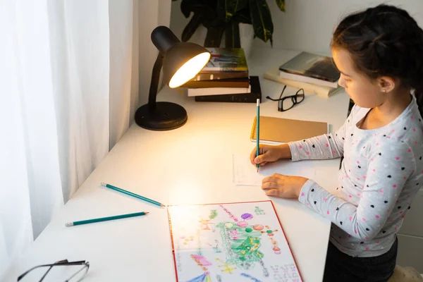 Crianças, educação e conceito de aprendizagem - menina estudante com escrita de livro para notebook em casa — Fotografia de Stock