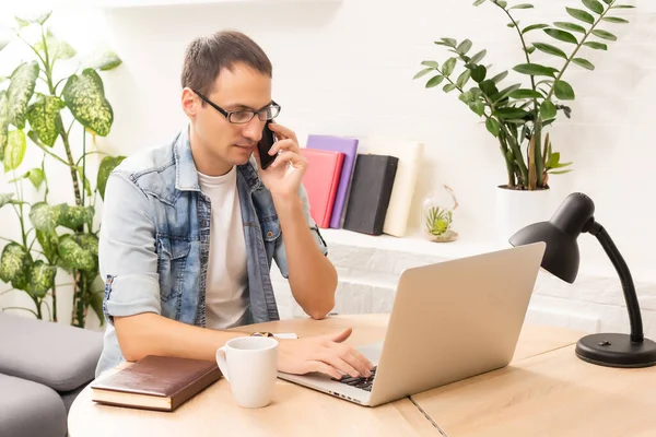 Teknoloji, uzaktan iş ve yaşam tarzı konsepti. Laptop bilgisayarlı mutlu adam görüntülü konuşma yapıyor ve ev ofisinde el sallıyor.