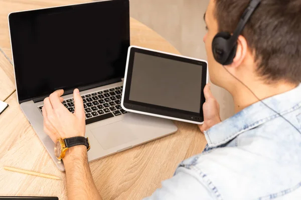 Aantrekkelijke Kaukasische zakenman die online conversatie met behulp van laptop en koptelefoon op kantoor bureau — Stockfoto