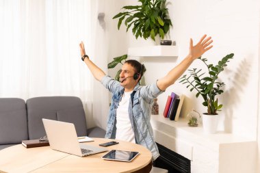 Adam evdeki masada dizüstü bilgisayar kullanıyor