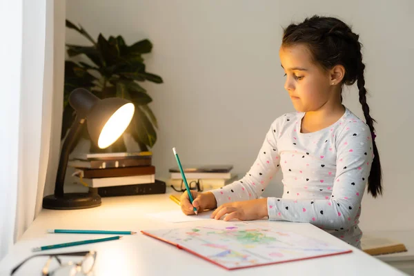 Дитяча дівчинка сміється, малює барвисті олівці на ігровому столі — стокове фото