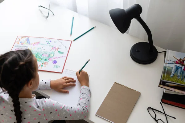 Niños, concepto de educación y aprendizaje - estudiante con escritura de libros a cuaderno en casa —  Fotos de Stock