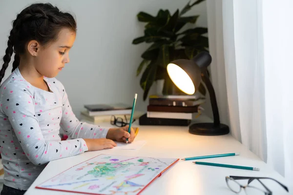 Criança menina rindo, pintando lápis coloridos em sua playtable — Fotografia de Stock