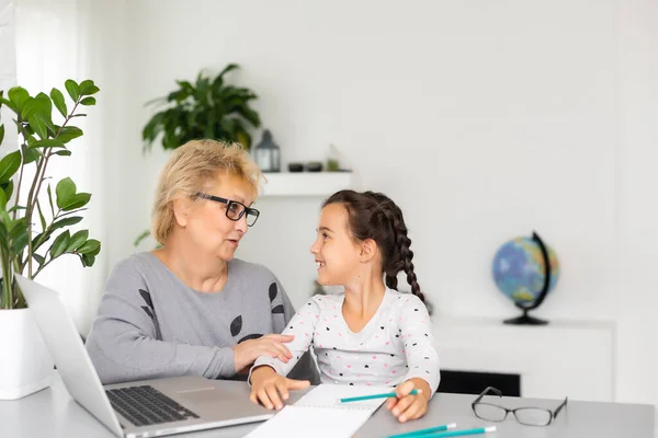 Nonna utile. Utile amorevole nonna assistere la sua nipote carino fare i compiti — Foto Stock