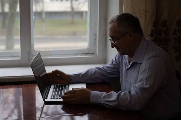 Senior che lavora su un computer portatile a casa — Foto Stock