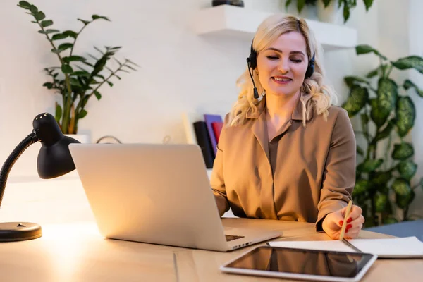 Portret van een gelukkige casual zakenvrouw zittend op haar werkplek in het kantoor — Stockfoto