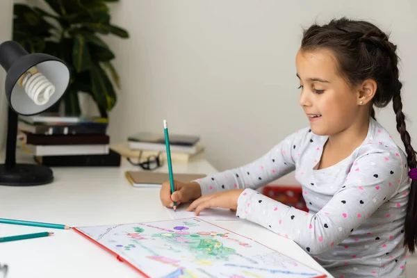 A child girl doing homework writing and reading at home — Stock Photo, Image