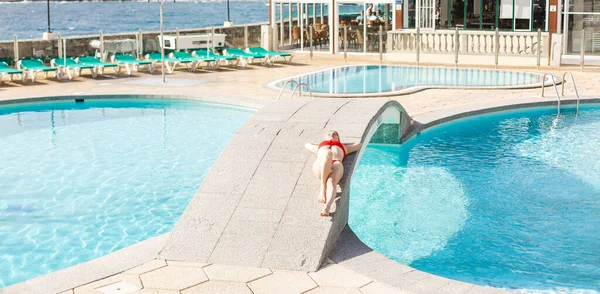 Jonge vrouw zonnebaden in de buurt van zwembad. — Stockfoto