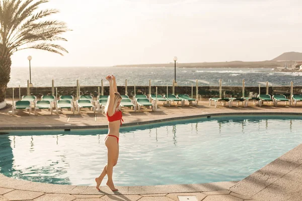 Belle jeune femme à Santa chapeau près de la piscine — Photo