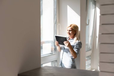 Güneş ışınları ve mercekli tablet kullanan kadın.