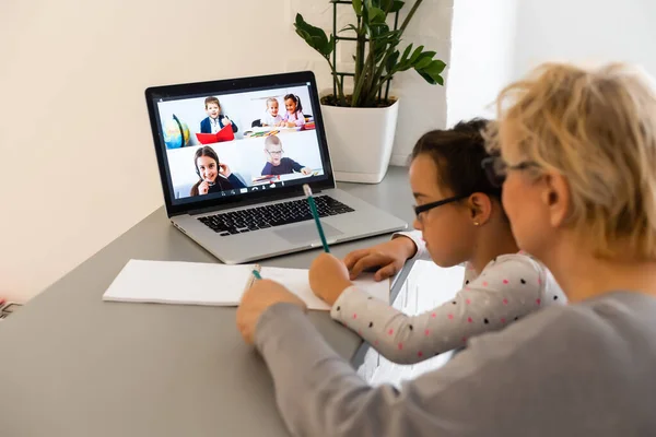 Niño lindo y feliz niña usando el ordenador portátil con su abuela, estudiando a través del sistema de e-learning en línea. —  Fotos de Stock