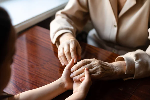 Very old woman holding the hands of a child — Stock Photo, Image