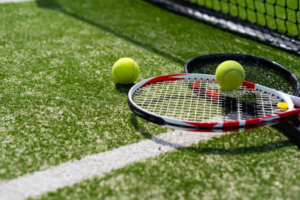 Tennisracket en nieuwe tennisbal op een pas geverfde tennisbaan — Stockfoto