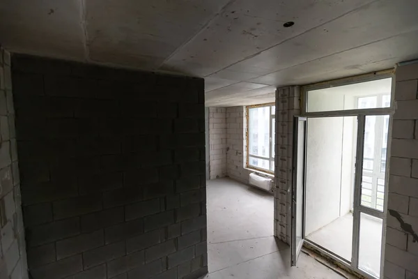 Kis lakás javítás nélkül egy új épületben. Egy szoba egy befejezetlen házban. Habtömb és betonpadló falai egy kis lakásban. — Stock Fotó
