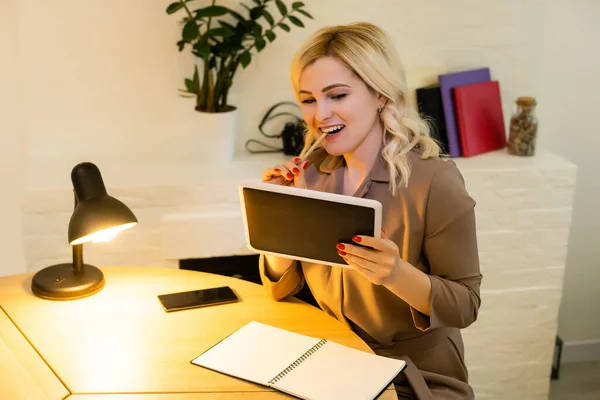 仕事中だ。テーブルに座っている若い長い髪の女性の手の閉じるとタブレットコンピュータ室内を使用して. — ストック写真