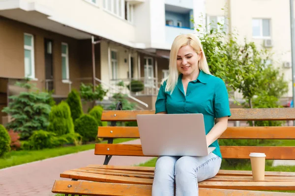Mujer buscando trabajo con un ordenador portátil en un parque urbano en verano — Foto de Stock