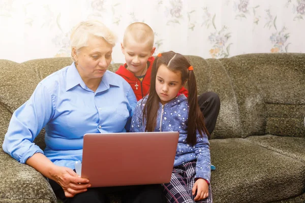 Nonna con nipoti che utilizzano il computer portatile a casa — Foto Stock