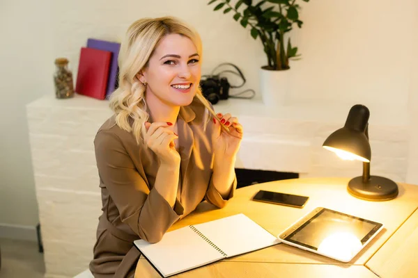 Retrato de uma mulher de negócios casual feliz sentada em seu local de trabalho no escritório — Fotografia de Stock