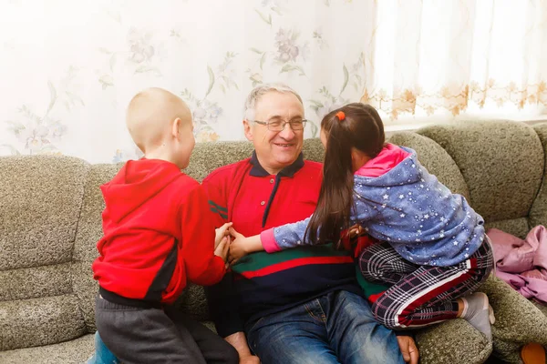 Opa brengt tijd door met kleinkinderen in de woonkamer — Stockfoto