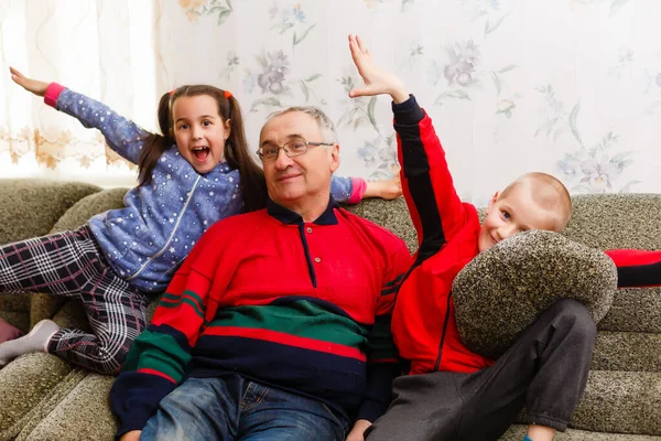 Grandparents spending time with grandchildren on couch — Stock Photo, Image