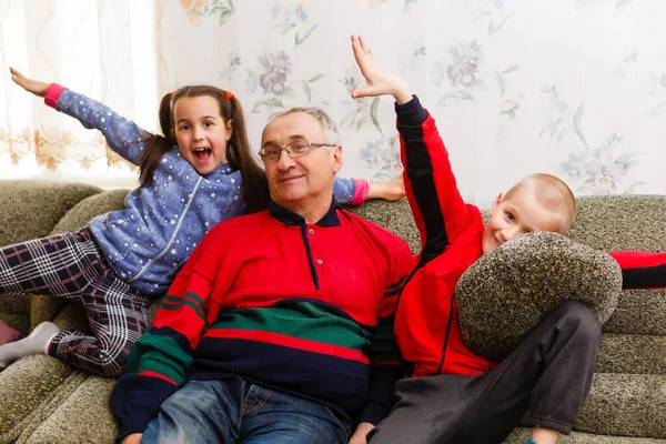 Grootouders die tijd doorbrengen met kleinkinderen op de bank — Stockfoto