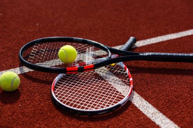 Tenis raketi ve yeni boyanmış tenis kortunda yeni bir tenis topu.