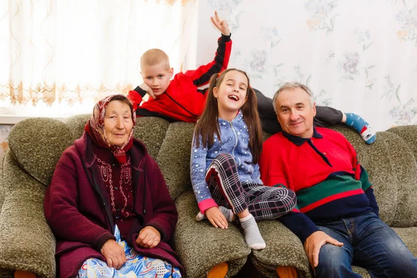 조부모와 함께 거실에서 소파에서 뛰놀고 있는 조부모들 — 스톡 사진