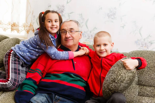 Nonni trascorrere del tempo con i nipoti sul divano — Foto Stock