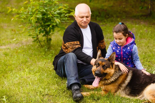 Dziadek i wnuczka relaksujący się z psem — Zdjęcie stockowe