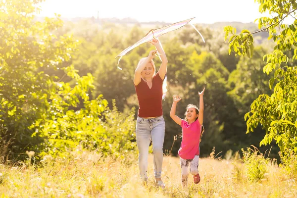 Junge Frau und Mädchen fliegen einen Drachen — Stockfoto