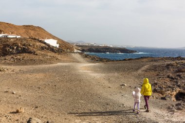 Anne ve iki çocuğu dağda yürüyüş yapıyor.