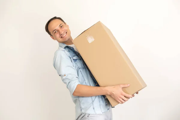 Uśmiechnięty dostawca trzyma dużą paczkę odizolowaną na białym — Zdjęcie stockowe