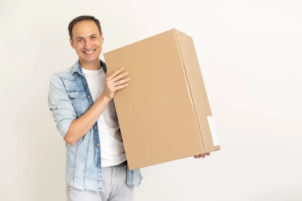 Lächelnder Zusteller mit einem großen Paket auf weißem Grund — Stockfoto