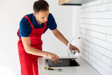 Tesisatçı mutfak lavabosuna silikon dolgu maddesi koymuş.