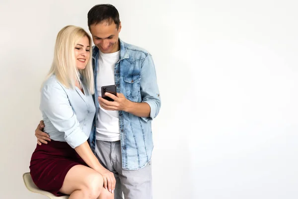 Piękna, ładna, ładna kobieta i przystojny mężczyzna w koszulach pisząc smsy przez 3g internet na smartfonach na szarym tle — Zdjęcie stockowe