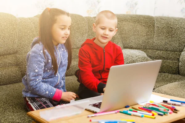 Дві красиві милі щасливі усміхнені діти, хлопчик і дівчинка, використовують ноутбук для дистанційного навчання або розваг . — стокове фото