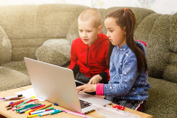 Twee mooie leuke gelukkig lachende kinderen, een jongen en een meisje, gebruik laptop voor afstandsonderwijs of entertainment. — Stockfoto