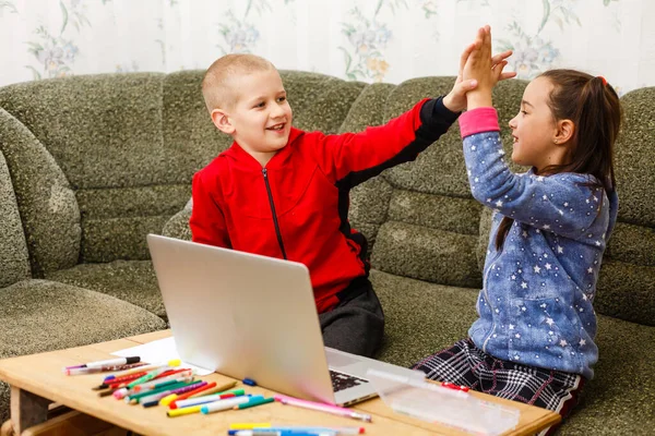 Educazione online all'apprendimento a distanza. ragazzo della scuola e la ragazza che studia a casa con notebook portatile e fare i compiti. Seduti a un tavolo — Foto Stock