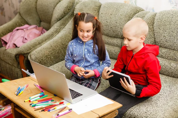 Due bei bambini sorridenti felici carini, un ragazzo e una ragazza, usano il computer portatile per l'apprendimento a distanza o l'intrattenimento. — Foto Stock