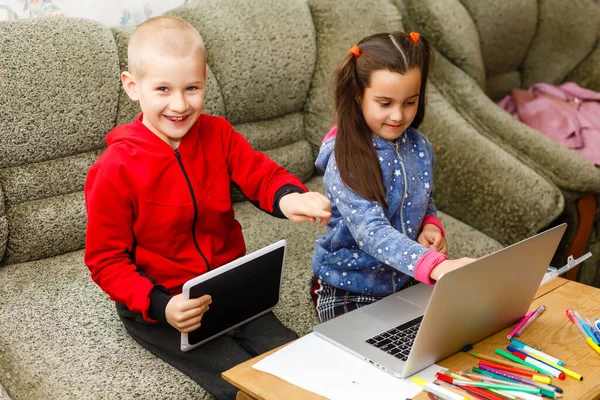 Online onderwijs op afstand. school jongen en meisje thuis studeren met laptop notebook en huiswerk maken. Zittend aan tafel — Stockfoto