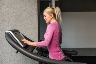 Yarış pistindeki genç kız, koşu bandındaki kadın.