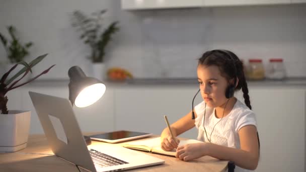 Küçük kız Studen evde dizüstü bilgisayarla online ders çalışıyor. Covid-19 Coronavirüs — Stok video
