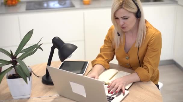 Fernarbeit von zu Hause aus. Junge Frau mit Laptop. Freiberuflicher Arbeitsplatz im Küchenbüro. — Stockvideo