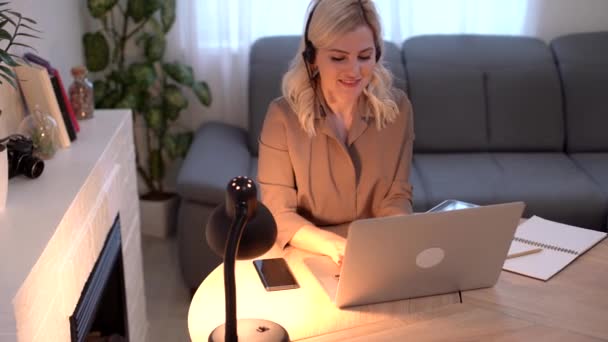 Una chica feliz trabaja remotamente desde casa y se comunica a través de videollamadas con amigos y familiares en su oficina. Aprendizaje a distancia y trabajo online. Uso de ordenador. — Vídeos de Stock