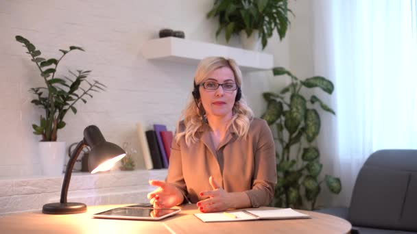 Mujer conduce conferencia en línea. Trabajo remoto freelancer en el lugar de trabajo en casa. — Vídeos de Stock