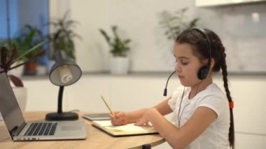 Küçük kız Studen evde dizüstü bilgisayarla online ders çalışıyor. Covid-19 Coronavirüs