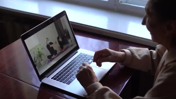 An elderly woman looking at a laptop about covid — Stock Video