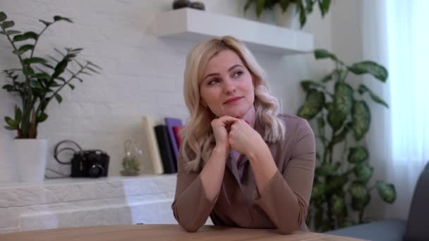 Portrait of a happy casual businesswoman sitting at her workplace in office — Stock Video