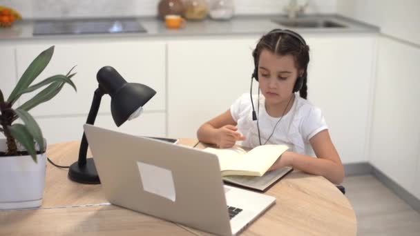Kids distance learning. Cute little girl using laptop at home. Education, online study home studying — Stock Video